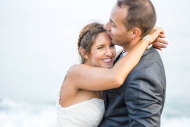 Gelin ve damat birbirine sahilde sarılma