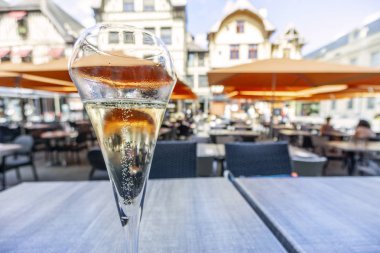 Glass of champagne in restaurant at market square of Troyes, capital city of this drink, France clipart