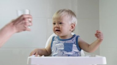 Anne tarafından verilen camdan su içme sevimli bebek