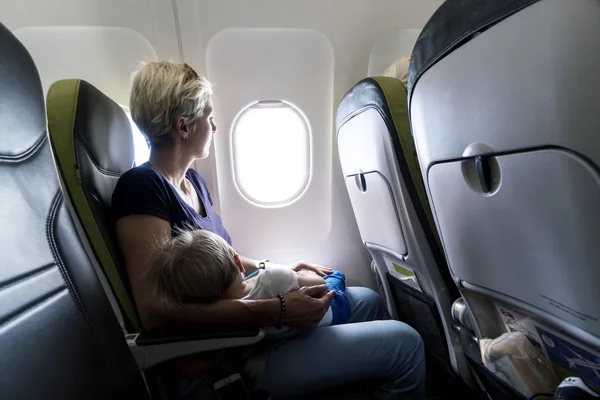 Mother with her sleeping baby boy during the flight — Stock Photo, Image