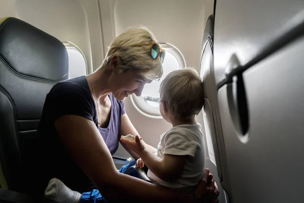 Мама проводит время со своим годовалым мальчиком во время полета — стоковое фото