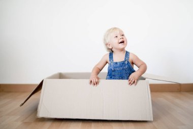 Sevimli küçük çocuk kutudan atlıyor.