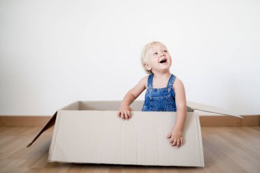 Sevimli küçük çocuk kutudan atlıyor.