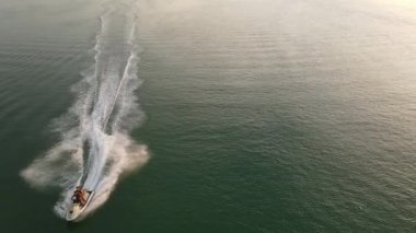 Çift, Algarve, Portekiz 'de gün batımının, süratin ve suyun tadını çıkarıyor.
