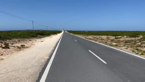 Strakke weg naar vuurtoren gelegen aan het einde van Saint Vincent Cape, Algarve, Portugal — Stockvideo