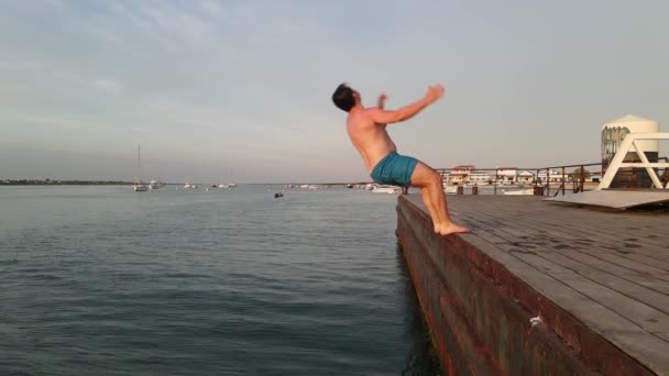 Mann springt rückwärts vom Steg ins Wasser, Insel Armona, Portugal — Stockvideo