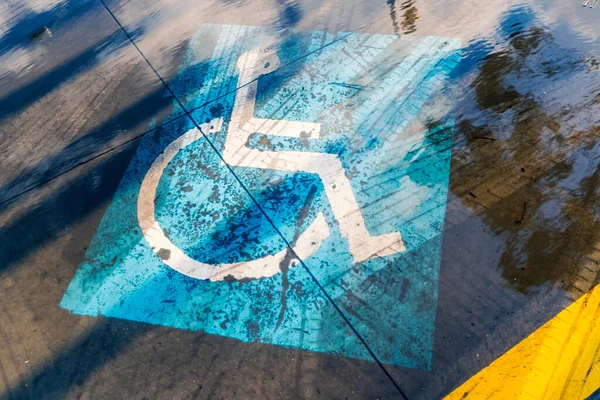 Flooded handicapped sign on the outdoor urban parking lot.