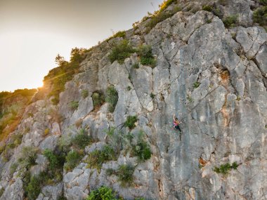 Portekiz 'de kayalara tırmanan koşumlu bir kadın.