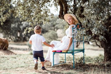 Hamile bir kadın doğada oğluyla vakit geçiriyor.