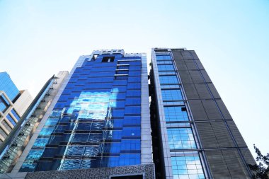 Dhaka şehrinde açık bir gün. Mimari yapılar gün ışığında camlardan yansıyor.