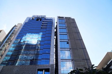 Dhaka şehrinde açık bir gün. Mimari yapılar gün ışığında camlardan yansıyor.