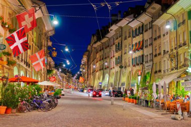 Bern, İsviçre - 21 Ağustos 2013: Kramgasse ile akşam Bern, İsviçre'nin eski şehir merkezinde alışveriş caddesi