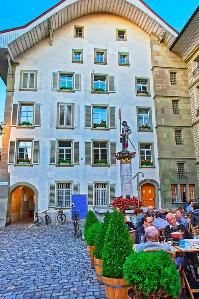Bern, İsviçre - 21 Ağustos 2013: İnsanlara kaldırım café Rathausplatz eski şehir merkezinde Bern, İsviçre için akşam Banneret Çeşme