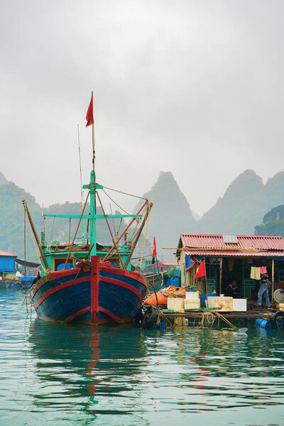 Halong, Vietnam - February 23, 2016: Ship at floating fishing village on Ha Long Bay, Vietnam, Asia