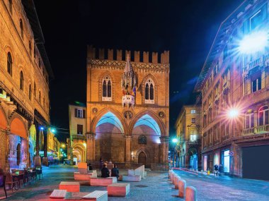 İtalya, Emilia-Romagna, Bologna 'daki Piazza della Mercanzia Meydanı' ndaki Palazzo della Mercanzia Sarayı 'ndaki insanlar. Gecenin geç saatlerinde