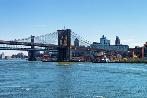 View from Ferry on Brooklyn bridge and Manhattan bridge above East River. Bridges connect Lower Manhattan with Brooklyn Heights of New York, the USA.