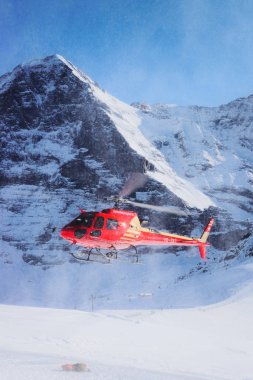 Maennlichen, İsviçre - 31 Aralık 2013: Kışın, İsviçre İsviçre alp dağ Maennlichen uçan kırmızı helikopter