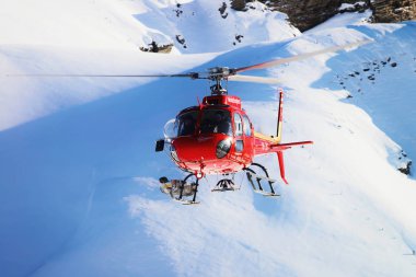 Maennlichen, İsviçre - 31 Aralık 2013: Kırmızı helikopter uçuş İsviçre Alpleri Mountain Maennlichen kış, İsviçre