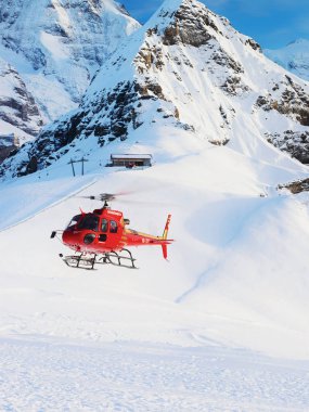 Maennlichen, İsviçre - 31 Aralık 2013: İsviçre Alpleri dağlar Maennlichen, kış aylarında İsviçre uçan kırmızı helikopter