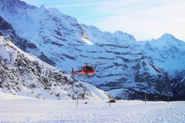 Maennlichen, İsviçre - 31 Aralık 2013: İsviçre Alp dağlarında Maennlichen, kış aylarında İsviçre uçan kırmızı helikopter