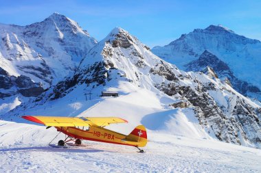 Maennlichen, İsviçre - 31 Aralık 2013: Sarı uçak Maennlichen içinde alp dağ zirveleri kış İsviçre Alpleri üzerinde
