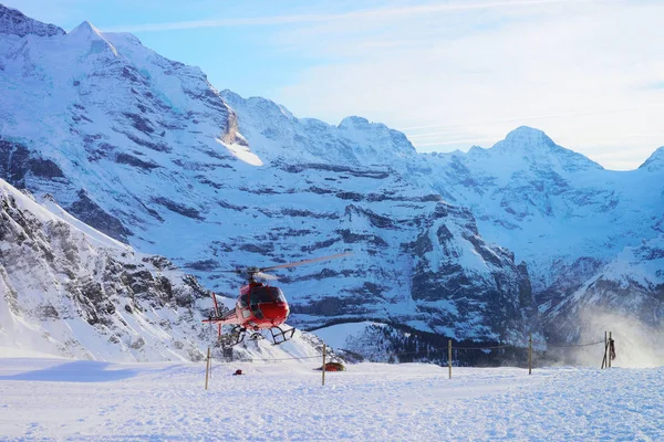 Maennlichen 2013年12月31日 Maennlichen 在瑞士阿尔卑斯山附近飞行的红色直升机在冬天 — 图库照片