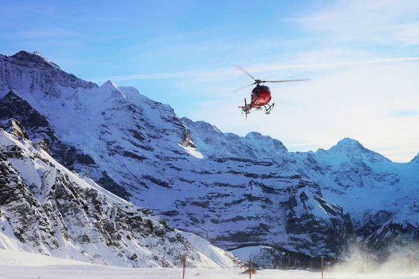 Maennlichen 2013年12月31日 红色直升机飞行在瑞士阿尔卑斯山 Maennlichen 在冬天 — 图库照片
