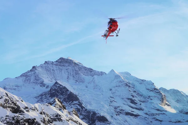 Maennlichen, İsviçre - 31 Aralık 2013: Kışın, İsviçre İsviçre Alpleri dağlar Maennlichen uçan kırmızı helikopter