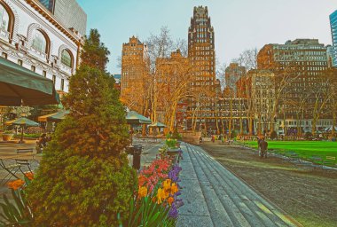 New York, Amerika Birleşik Devletleri - 24 Nisan 2015: Yeşil bitkiler ve Bryant Park Midtown Manhattan, New York, ABD içinde gökdelenler. Gökdelenler ve turistler ve arka plan üzerinde.