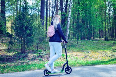 Druskininkai, Litvanya parkında itme scooter üzerinde genç kadın. Tonda