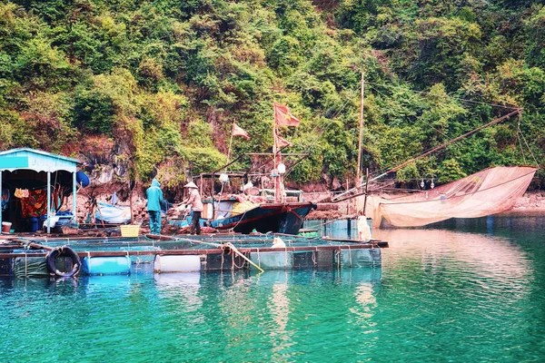 Boat near floating fishing village in Ha Long Bay, Vietnam