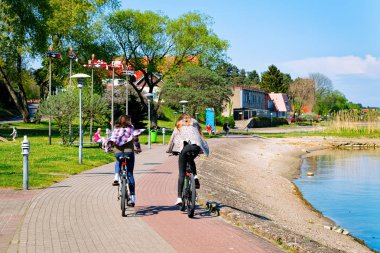 Bisiklete binen kızlar. Neringa Klaipeda yakınlarındaki Nida tatil kasabası, Curonian Spit ve Litvanya Baltık Denizi.