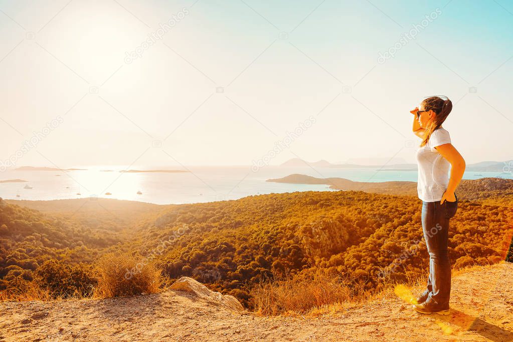 Girl looking at the Mediterranean Sea on Costa Smeralda, Olbia, in Sardinia in Italy