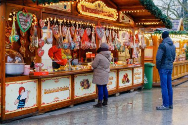 Berlin, Almanya - 11 Aralık 2017: Almanya'nın Kış Berlin kentindeki Kaiser Wilhelm Memorial Kilisesi'nde Noel Pazarı'nda tatlılı tezgahlarda insanlar. Advent Fuar Dekorasyon ve El Sanatları Öğeleri ile Tezgahları