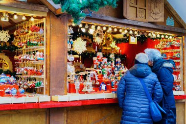 Berlin, Almanya - 11 Aralık 2017: Kış Berlin'deki Kaiser Wilhelm Memorial Kilisesi'nde Noel Pazarı'ndaki tezgahta insanlar. Advent Fuar Dekorasyon ve El Sanatları Öğeleri ile Tezgahları