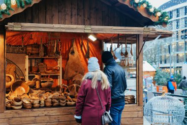 Kış Berlin'de Kaiser Wilhelm Memorial Kilisesi'nde Noel Pazarı Stall İnsanlar, Almanya. Çarşıda El Sanatları Öğeleri ile Advent Fuar Dekorasyon ve Tezgahlar.