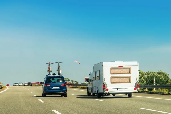 RV Camper with bicycles and car on Road. Caravan and motorhome in trip at Switzerland.