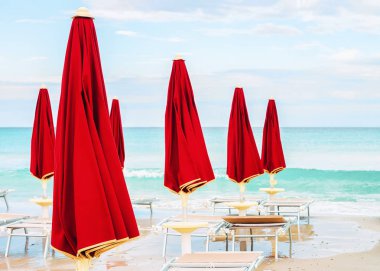 İtalya'nın Sardunya Adası'ndaki San Teodoro'daki La Cinta plajı ve Akdeniz'in mavi sularında şemsiyeler