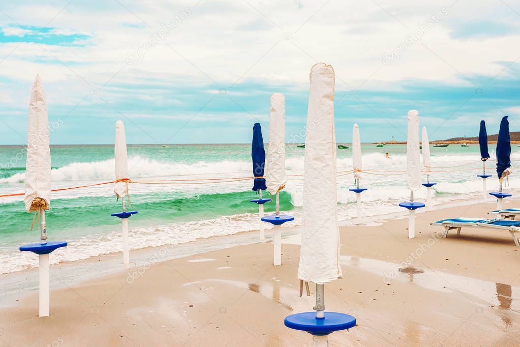 Umbrellas at La Cinta beach and Blue waters of Mediterranean Sea of San Teodoro in Sardinia Island in Italy