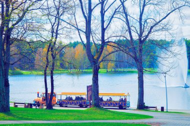 Druskininkai, Litvanya - 30 Nisan 2017: Turistlerle gezi treni, Druskonis Gölü'nde su çeşmesi ve Litvanya'nın Druskininkai kentinde doğa. Tonda