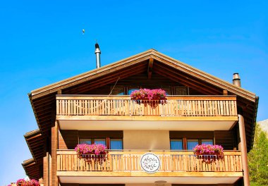 Zermatt, İsviçre - 24 Ağustos 2016: İsviçre 'nin Zermatt tatil beldesinde balkonlarda çiçekli geleneksel İsviçre dağ evi
