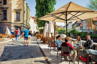 Ljubljana, Slovenya - 29 Nisan 2018: Ljubljana, Slovenya'nın tarihi merkezindeki Ljubljanica Nehri'nin setindeki kaldırım kafede insanlar