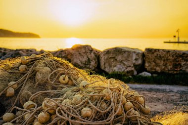 Adriyatik denizindeki Izola köyündeki marinada gün batımında balık ağı, Slovenya