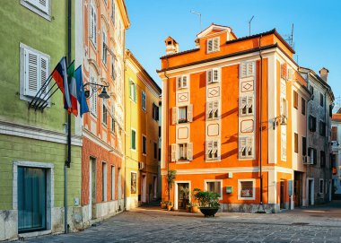 Slovenya'nın Izola eski kentinin tarihi meydanındaki binadaki bayraklar