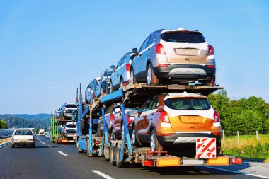 Cars carrier truck at the asphalt highway in Poland. Truck transporter clipart