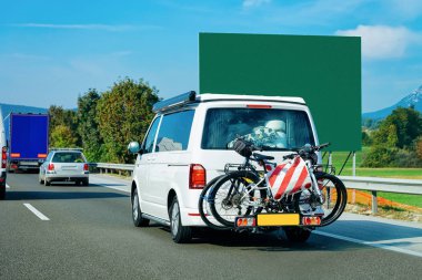 Slovenya'da Yolda bisikletli mini minibüs.