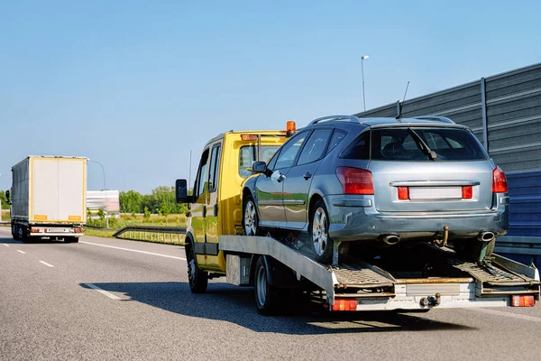 Tow truck transporter carrying car on the Road in Slovenia.