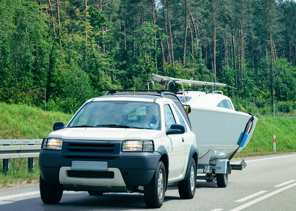 Car with a boat in Car trailer in the roadway in Poland.