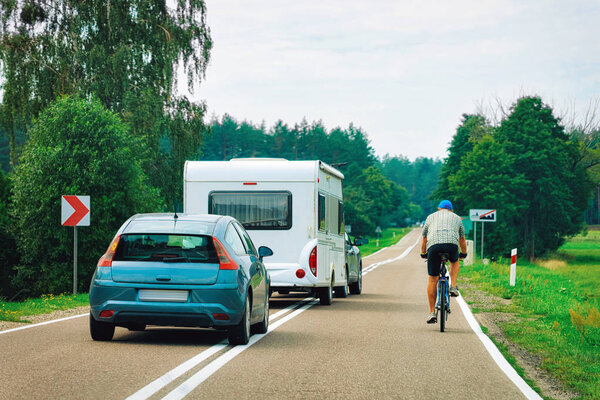 Автомобиль, кемпер и человек на велосипеде на дороге в Варшаве в Польше

