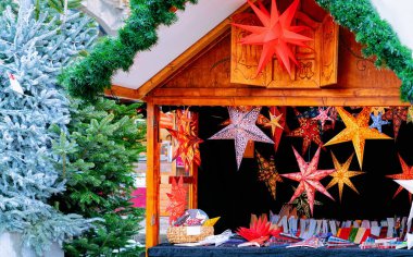 Kış Berlin Noel Pazarı'nda Kağıt Noel yıldızı dekorasyon, Almanya. Advent Fuarı ve Çarşıda El Sanatları Öğeleri ile Tezgahlar.